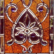 Stained glass combination window with high-profiled, hand-faceted jewels and beveled tracery.