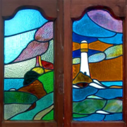 Antique Art Deco stained glass window pair with lighthouse and rolling-hills pastoral scene, catalog AE339